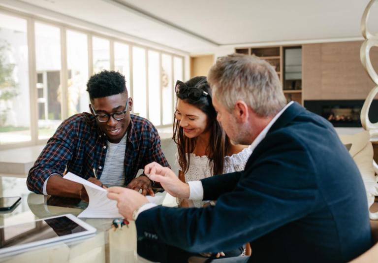 Couple signs paperwork in an office