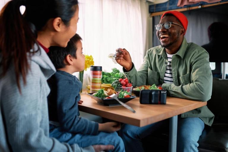 Family enjoys dinner together inside an RV