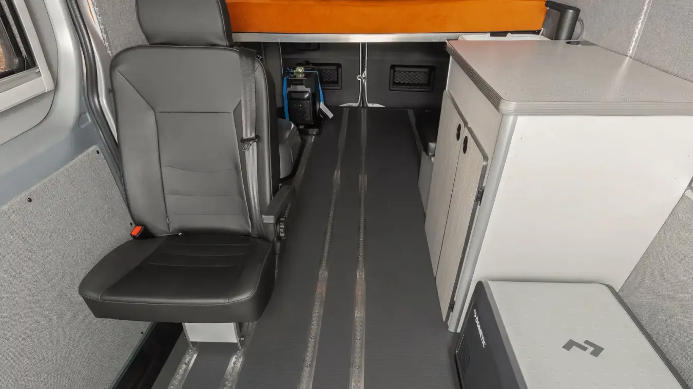 View of counter, bed, and rear passenger seat inside the Winnebago Adventure Wagon