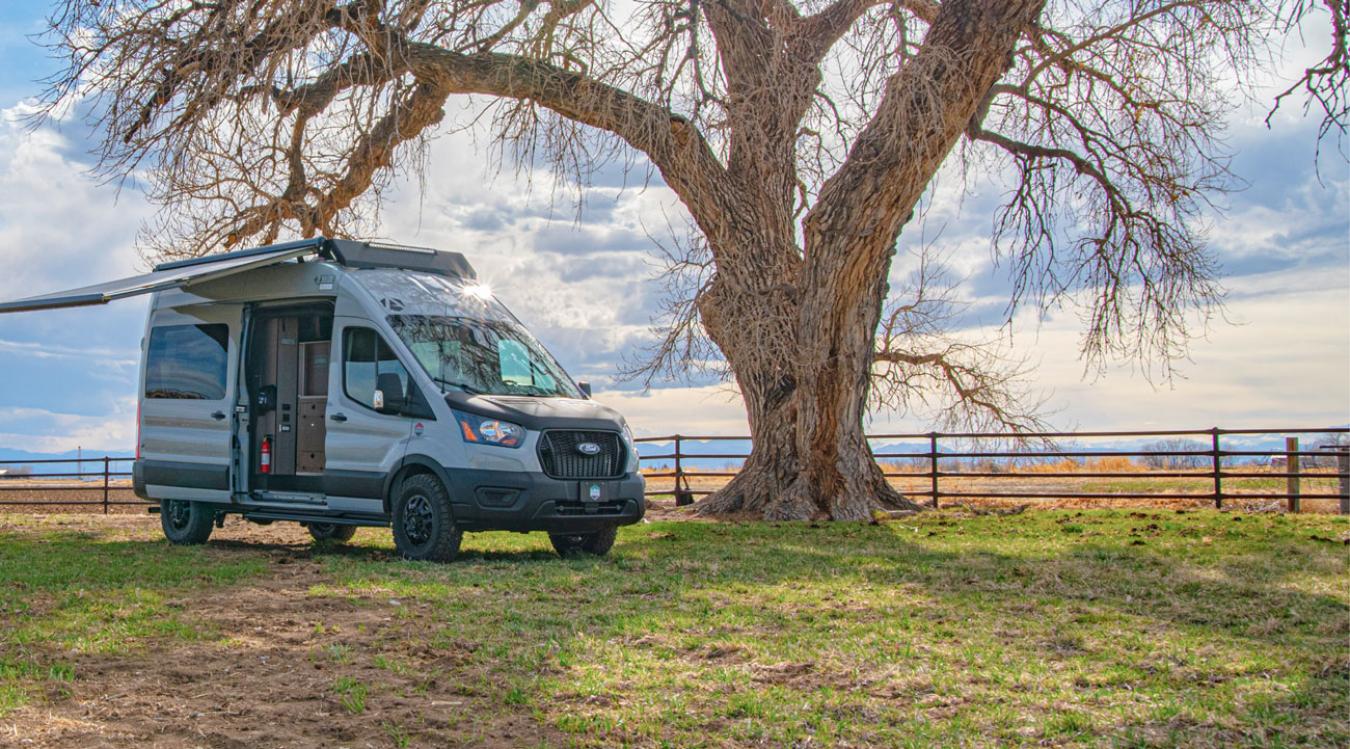 A wide shot of an Antero Adventure Van beneath a tree