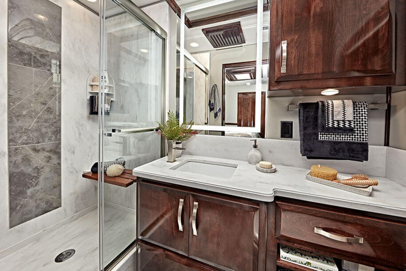 Bathroom inside a Renegade RV with marble-like finishes and dark cabinets
