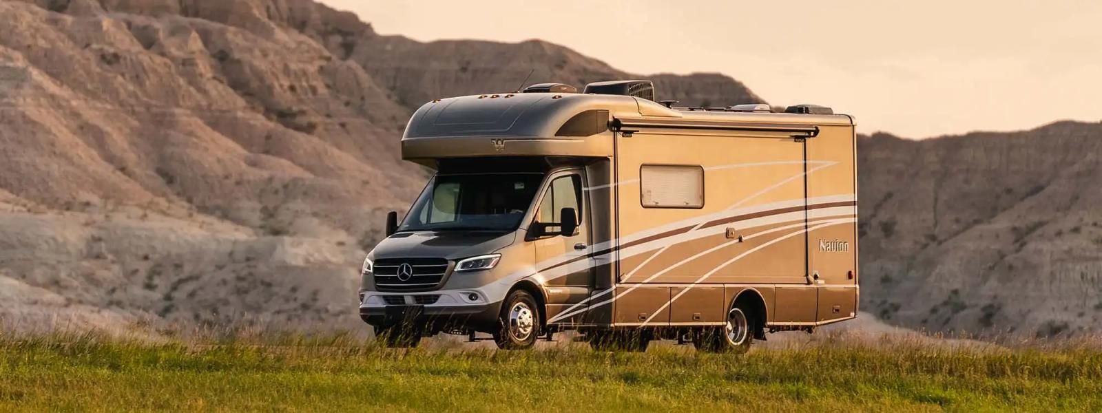 2023 Winnebago Navion parked in front of a desert mountain