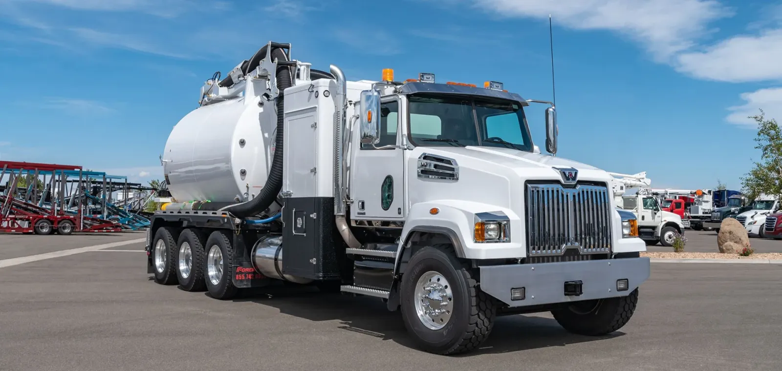 A white hydrovac truck in an empty parking lot