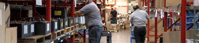 Men getting parts from trailer stock room