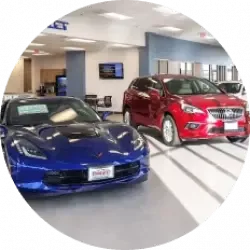 A blue sports car next to a red SUV in a car dealership lobby