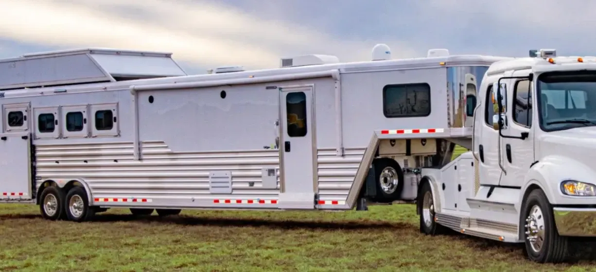 A horse and livestock trailer hitched onto a truck